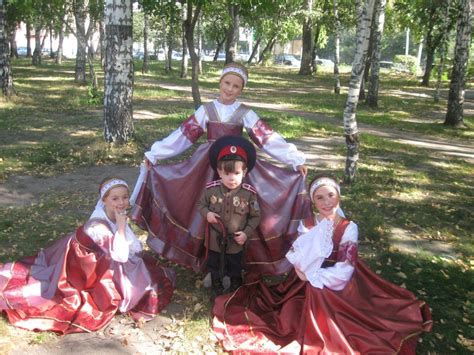 three cossack girls in traditional costumes and a little