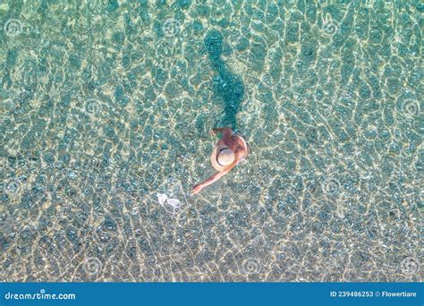 Top View Young Beautiful Naked Woman In A Hat Taking Off Bikini In Sea