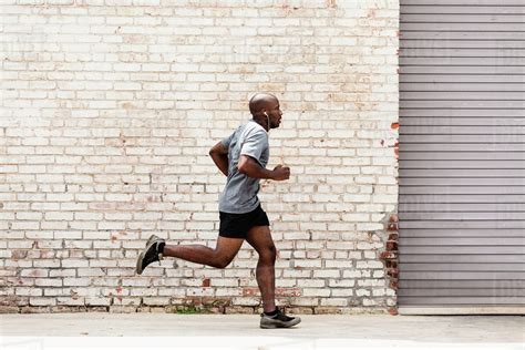 black man running  city sidewalk stock photo dissolve