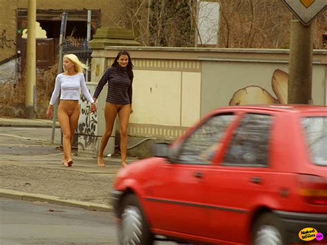 two girlfriends walk on the sidewalk with no panties on