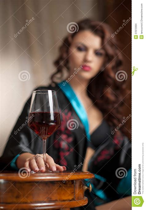 Beautiful Sexy Woman With Glass Of Wine Sitting On Chair
