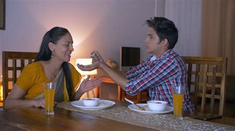 indian son feeding his mother while she caresses him mother