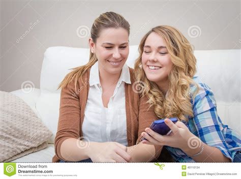 Mother And Daughter Laughing When Looking At Phone Stock
