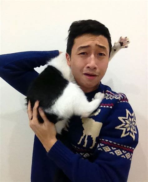 a man holding a black and white cat in his arms