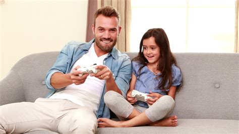 happy father and daughter playing video games on the sofa stock footage video 14798017