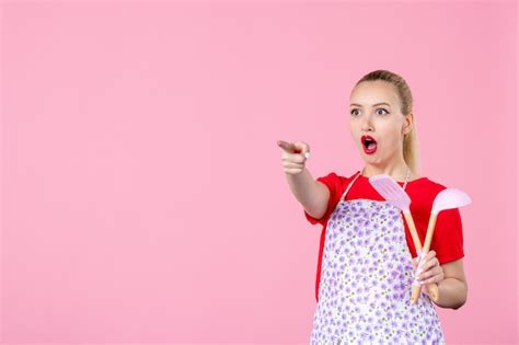 Free Photo Front View Young Housewife Holding Cutlery On Pink Wall