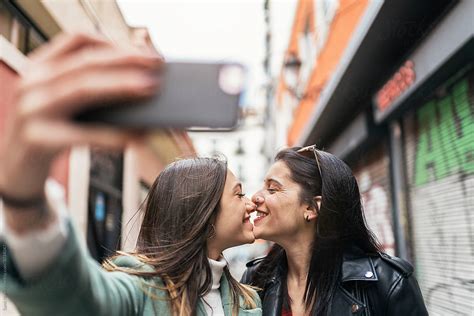 lesbian couple taking selfie by stocksy contributor santi nuñez