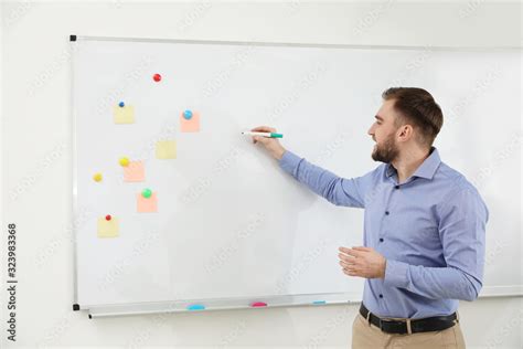 portrait  young teacher writing  whiteboard  classroom stock