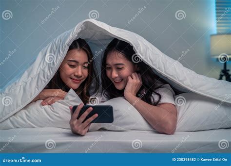 Asian Attractive Lesbian Couple Use Mobile Phone Watch Movie On Bed