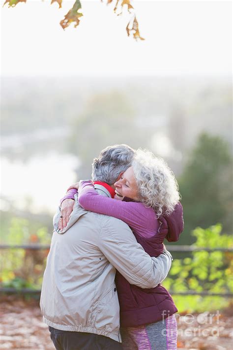 Affectionate Active Senior Couple Hugging In Park Photograph By Caia