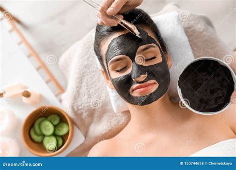 cosmetologist applying black mask  womans face  spa salon stock