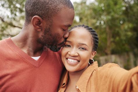 Affectionate Loving And Happy Couple Taking A Selfie Kissing On The