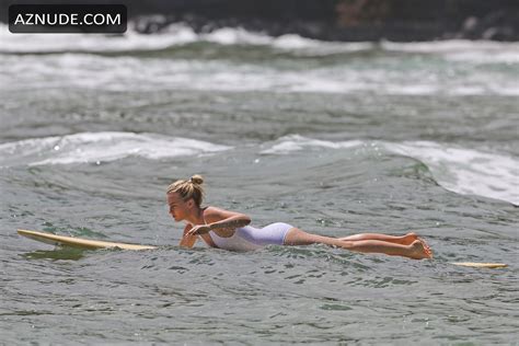 margot robbie sexy in a white one piece swimsuit surfing in hawaii aznude