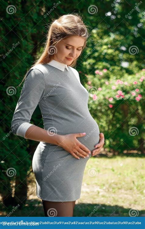 Beautiful Pregnant Girl In A Park On A Green Background Tenderness