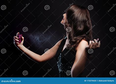 Attractive Young Brunette Woman And A Bottle With A New Fragrance Use