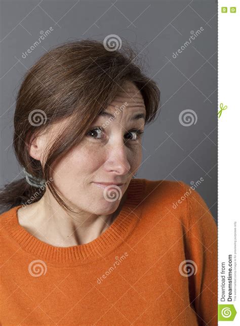 cheeky middle aged woman acting surprised smiling for