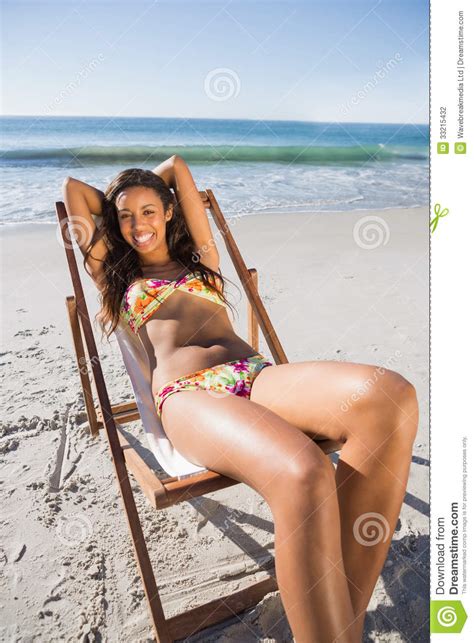 Cheerful Sexy Brunette Relaxing On Her Deck Chair Stock