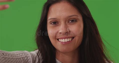 Close Up Portrait Of Attractive Young Lady Smiling At Camera On Green