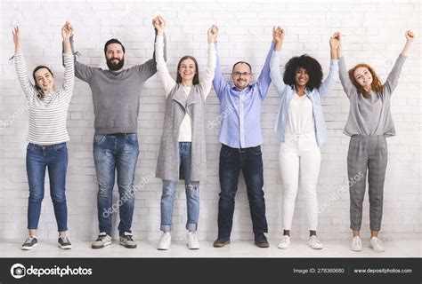 group  successful friendly people raising connected hands stock photo
