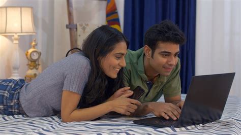 Cute Indian Couple Having Fun Together While Using A Laptop In