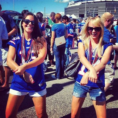 Two Women In Blue Shirts And White Shorts Standing Next To Each Other