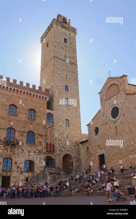 the sun behind the great tower torre grossa san gimignano tuscany