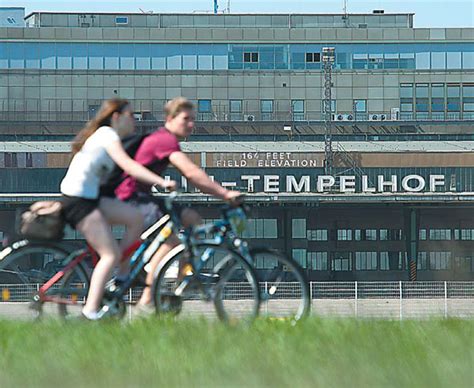 people cycle past the main terminal of tempelhof airport in berlin in april the airport a cold