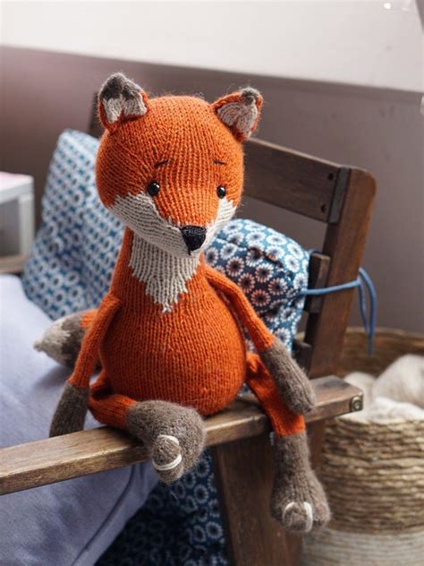 An Orange Knitted Fox Sitting On Top Of A Wooden Chair