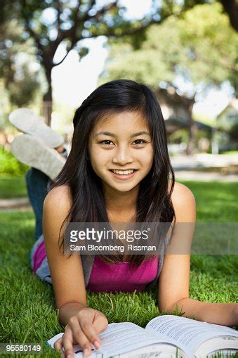 Asian Girl Laying In Grass Reading Book Photo Getty Images