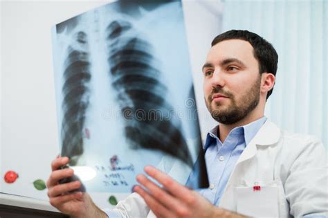 Close Up Portrait Of Doctor Looking At Chest X Ray In His Office Stock