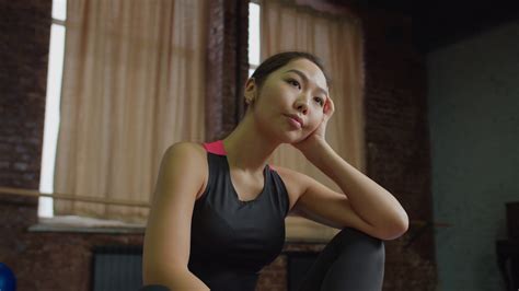 Portrait Of Tired Charming Fit Asian Woman In Sportswear Relaxing After