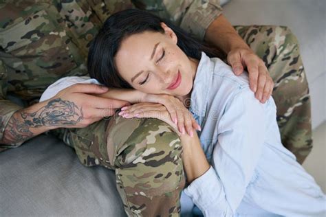 Peaceful Wife Sleeping On Leg Of Her Military Husband Stock Image