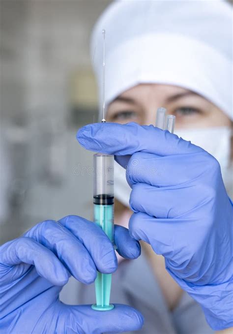 Medical Worker Nurse Close Up In Blue Gloves With A Syringe In Her