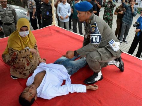 indonesian man faints during public whipping for sharia banned sex