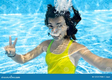girl swims  swimming pool underwater happy active teenager dives   fun  water kid
