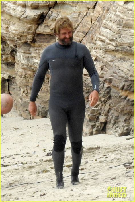 gerard butler puts on his skintight wetsuit for a day of