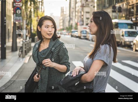 Two Girlfriends Meeting Outdoors And Having Fun Japanese People