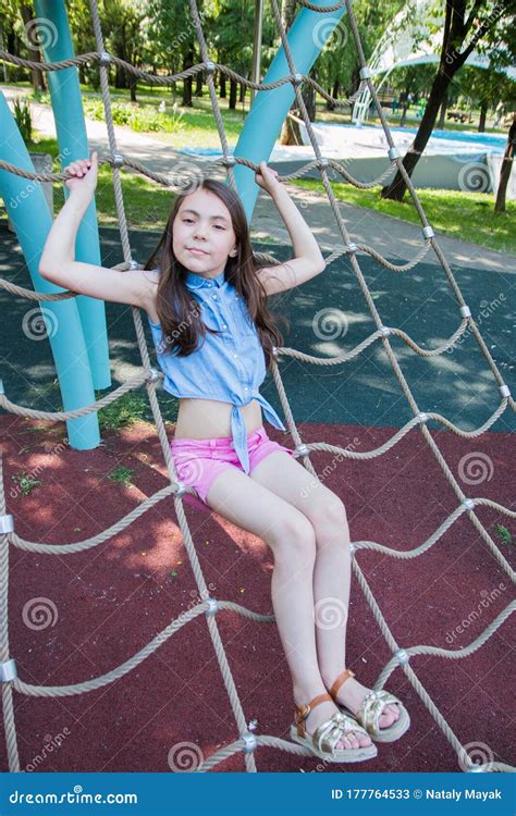Portrait Of Girl Playing On Playground In Park In Summer Time Summer