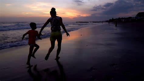 Mother Running With Her Son On The Beach At The Evening Slow Motion