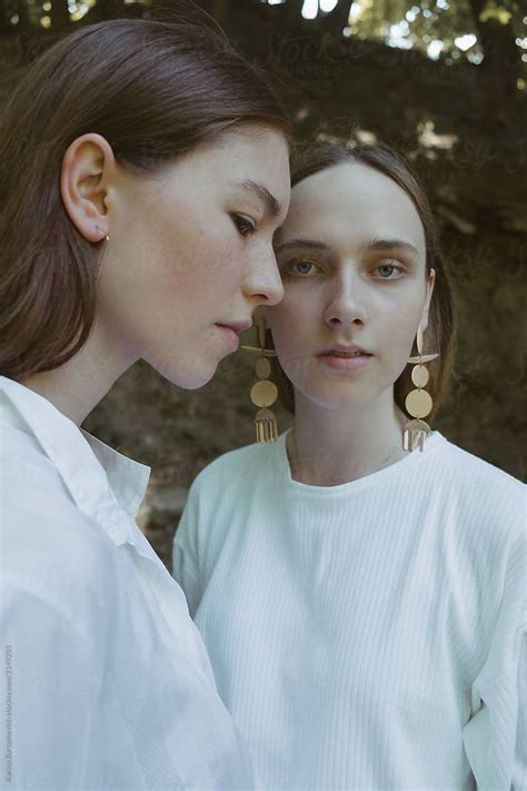 portrait of two natural beautiful girls in white and vintage earrings