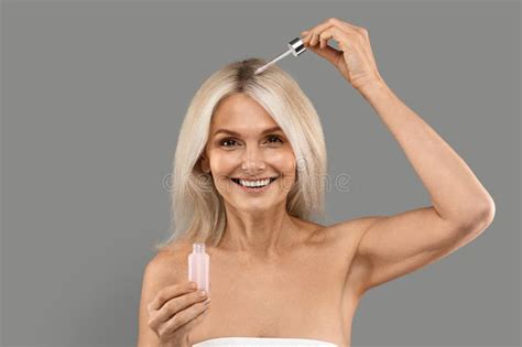 Beautiful Mature Woman Applying Hair Serum With Droplet Stock Image