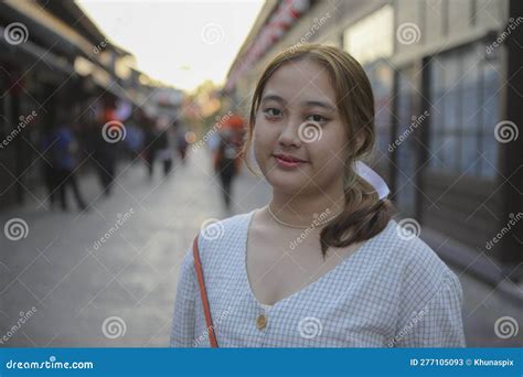 Portrait Of Chubby Asian Woman Standing Outdoor Against Japanese