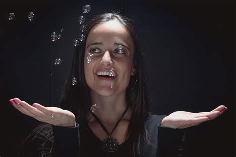 Premium Photo Happy Young Woman Playing With Bubbles Against Black