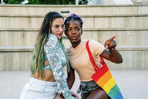 happy interracial lesbian couple embracing photograph by cavan images