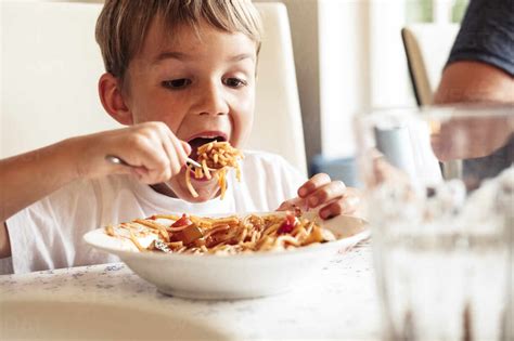 portrait  boy eating spaghetti stock photo