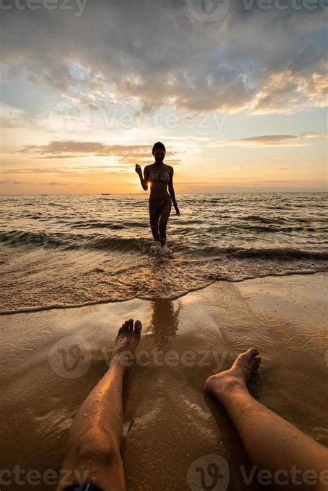 woman silhouette   beach  sunset  man legs  stock