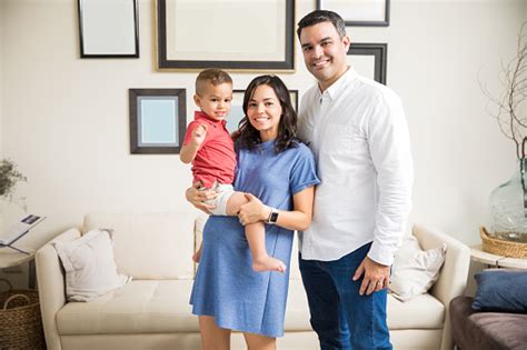 Smiling Pregnant Woman Carrying Son By Man At Home Stock