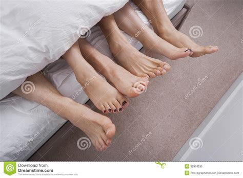 low section of woman with two men in bed royalty free