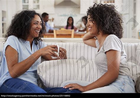 mother talking with teenage daughter on sofa royalty