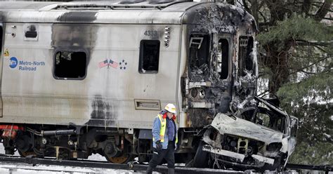 investigators examine burned wreckage  deadly train crash
